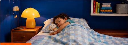 Toddler lying in bed at night with a stuffed animal.